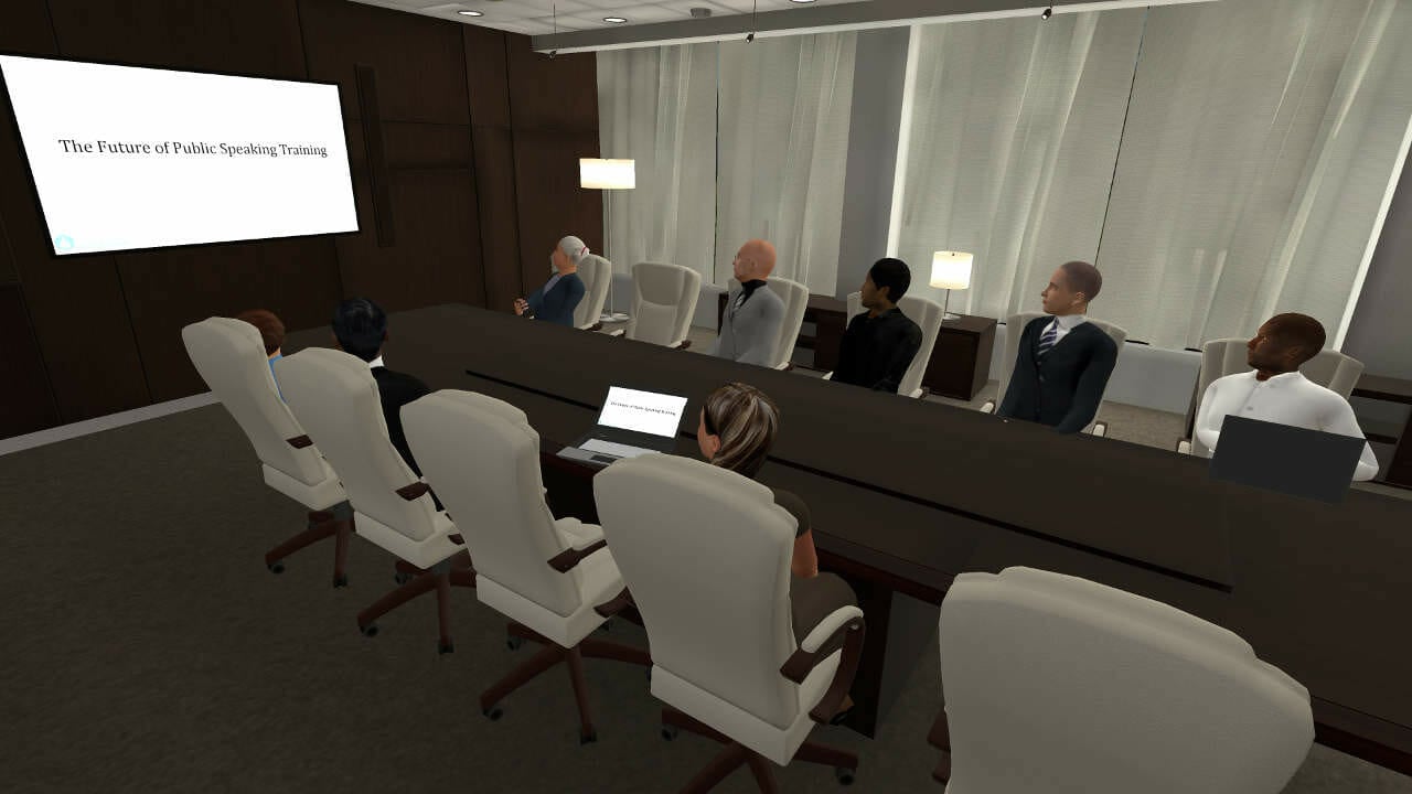 An image of a meeting room with people having a meeting in it